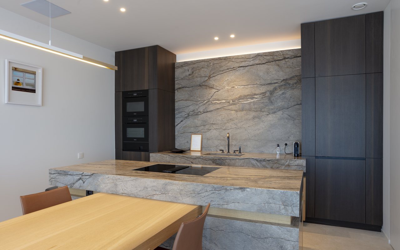 Keuken met werkblad en wandbekleding in natuursteen